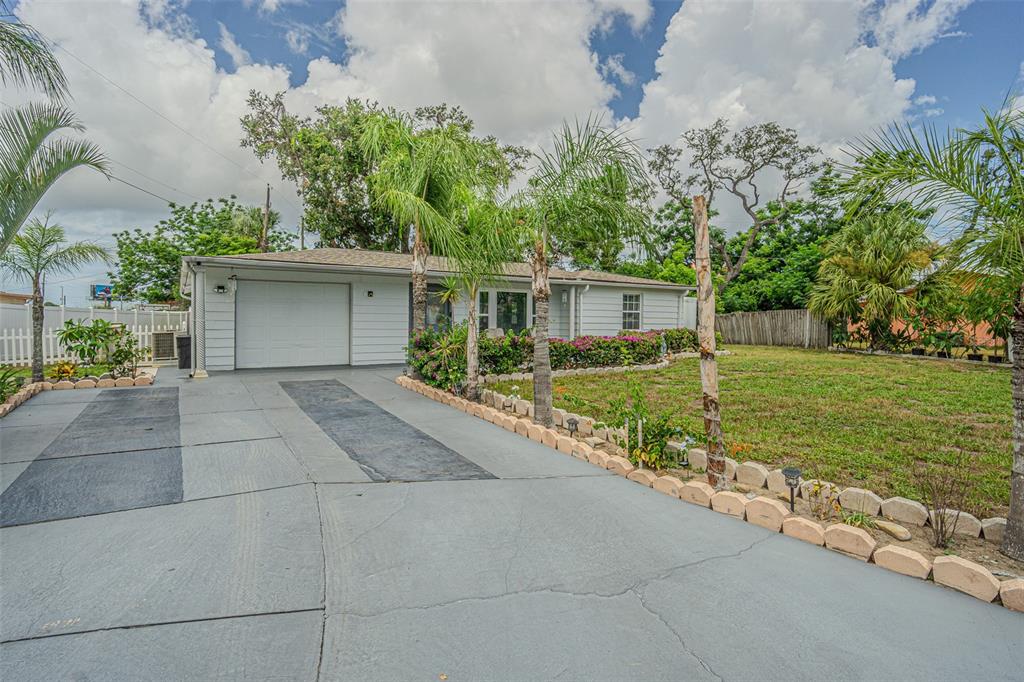 A single-story house with a gray exterior, a garage, and a palm-lined driveway — 3731 LATIMER STREET, NEW PORT RICHEY, FL