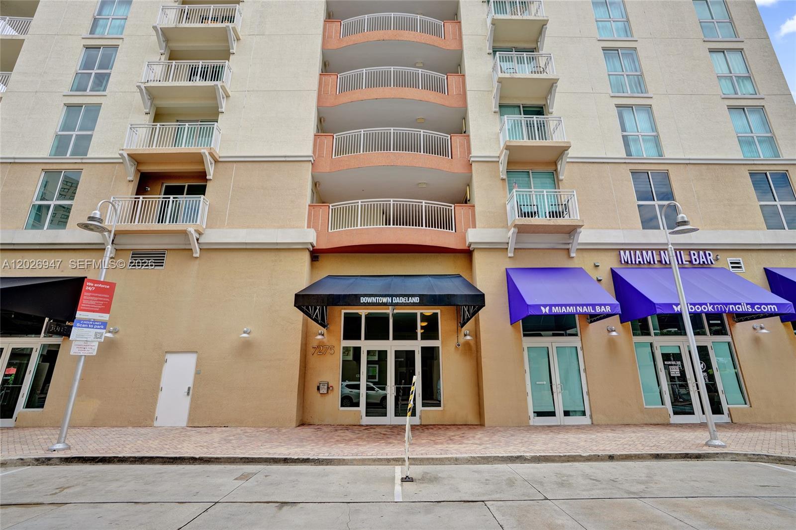 The exterior of a multi-story building features a central entrance with a black awning — 7275 SW 90th St # C410, Miami FL 33156, MIAMI, FL