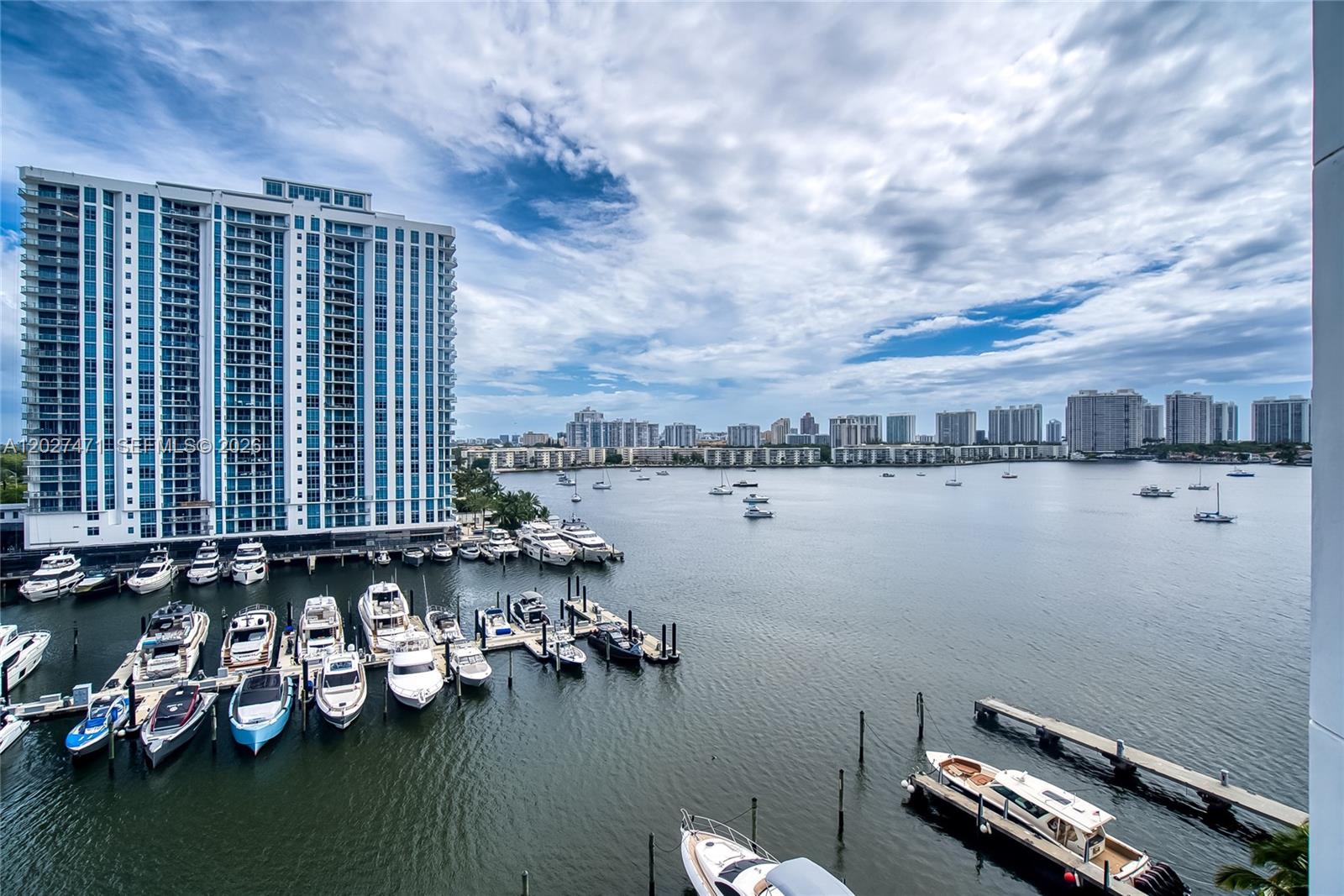 An elevated view of a marina with numerous docked boats and a high-rise building — NORTH MIAMI BEACH, FL