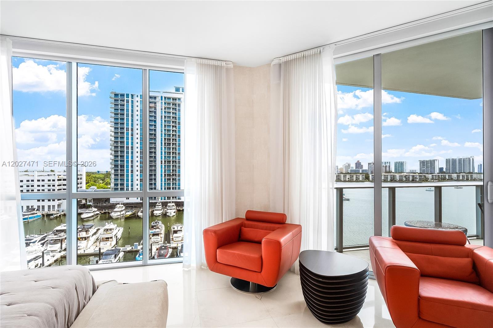 A living area features two red leather chairs, a dark side table, and floor-to-ceiling windows — NORTH MIAMI BEACH, FL