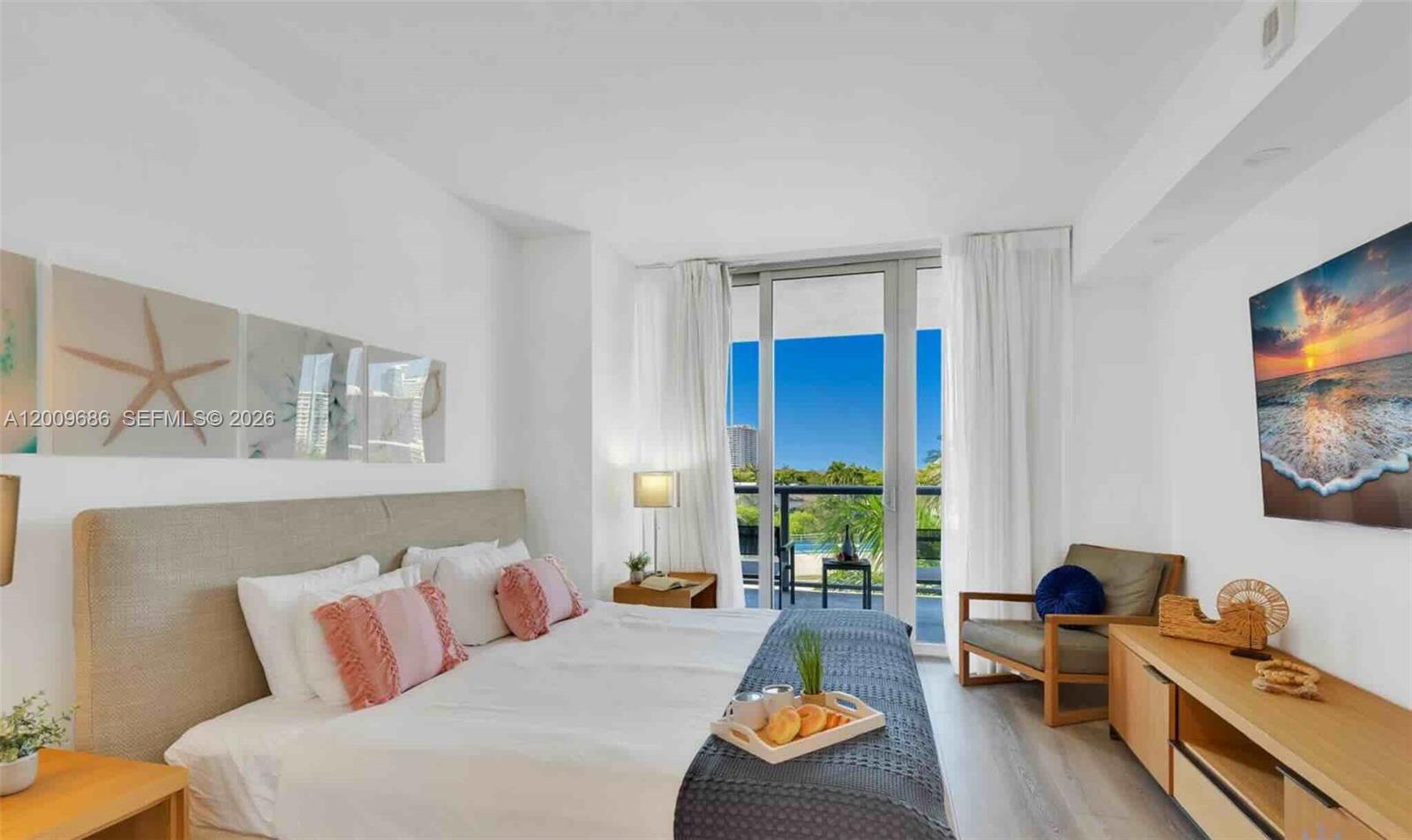 A bedroom features a king bed, a balcony with a view, and a wall-mounted television — 2602 E Hallandale Beach Blvd # R506, Hallandale Beach FL 33009, HALLANDALE BEACH, FL