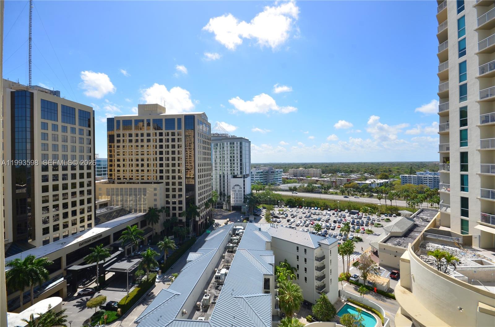 An elevated view shows a city skyline with office buildings, a parking lot, and residential towers — 9055 SW 73rd Ct # 1106, Miami FL 33156, MIAMI, FL