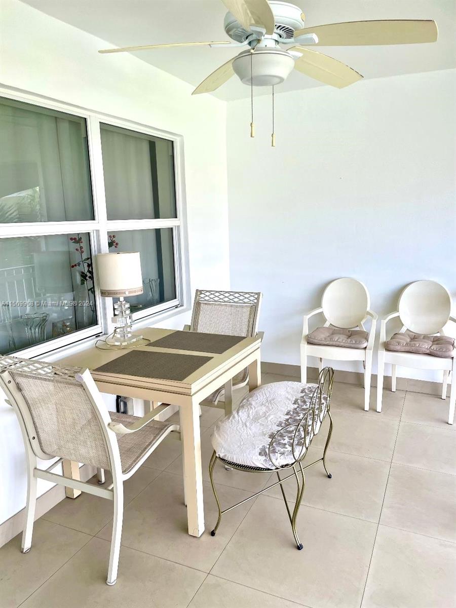 A sunroom features a dining table, chairs, a bench, and a ceiling fan — 580 Egret Dr # 308, Hallandale Beach FL 33009, HALLANDALE BEACH, FL