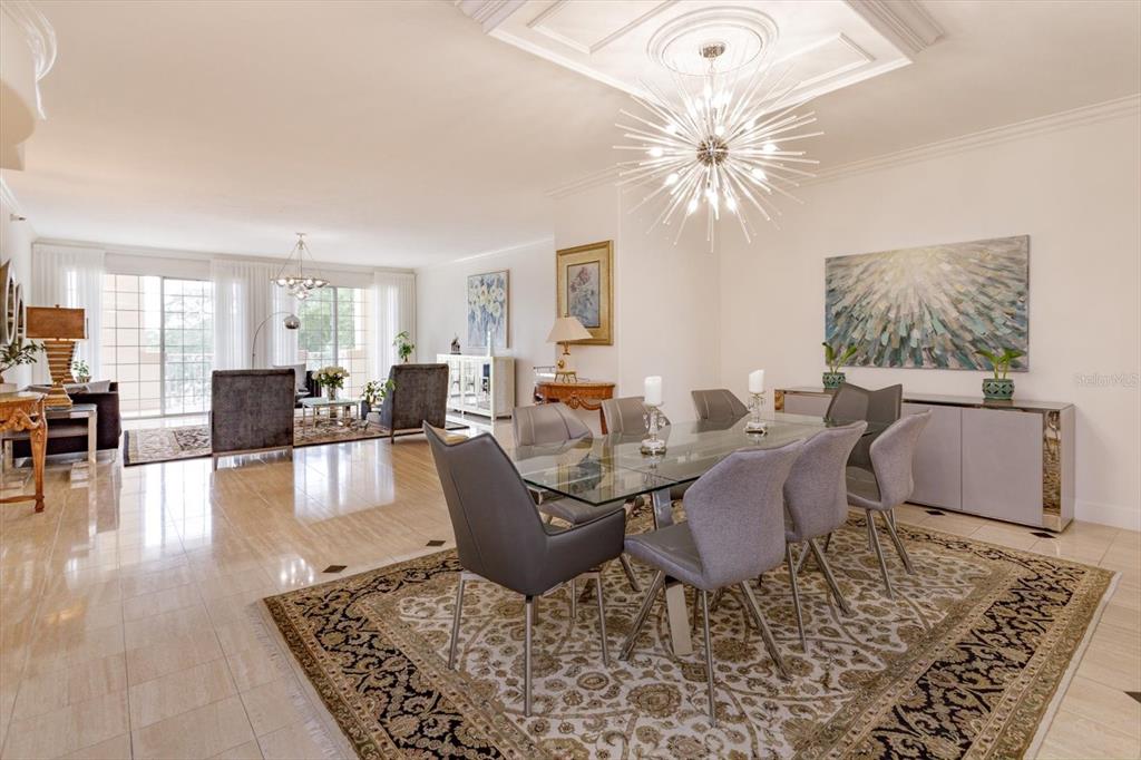 A dining area with a glass table and grey chairs sits on a patterned rug — 1110 W IVANHOE BOULEVARD UNIT 9, ORLANDO, FL