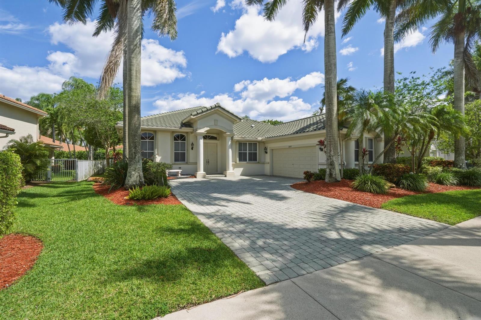 A single-story house with a paved driveway, palm trees, and a tiled roof — 2053 Quail Roost Drive, Weston FL 33327, WESTON, FL