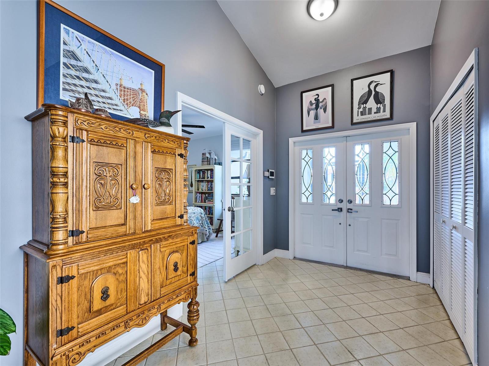 A foyer with tiled floors, a wooden cabinet, and double doors leading to an office — 19284 Cherry Hills Terrace, Boca Raton FL 33498, BOCA RATON, FL