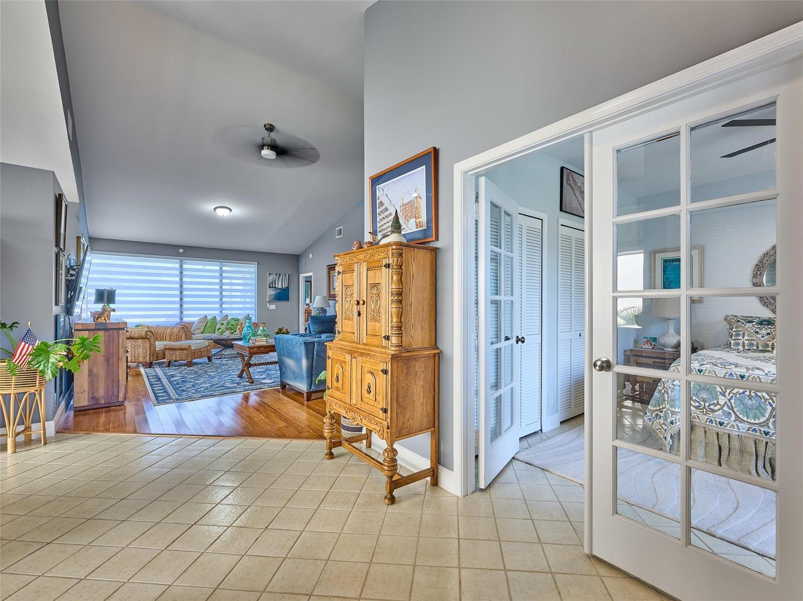 A tiled entryway leads to a living room with wood floors and a bedroom with French doors — 19284 Cherry Hills Terrace, Boca Raton FL 33498, BOCA RATON, FL