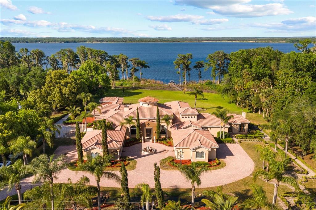 An aerial view of a large Mediterranean-style house with a tile roof and circular driveway — 1112 ORANGE AVENUE, WINTER SPRINGS, FL