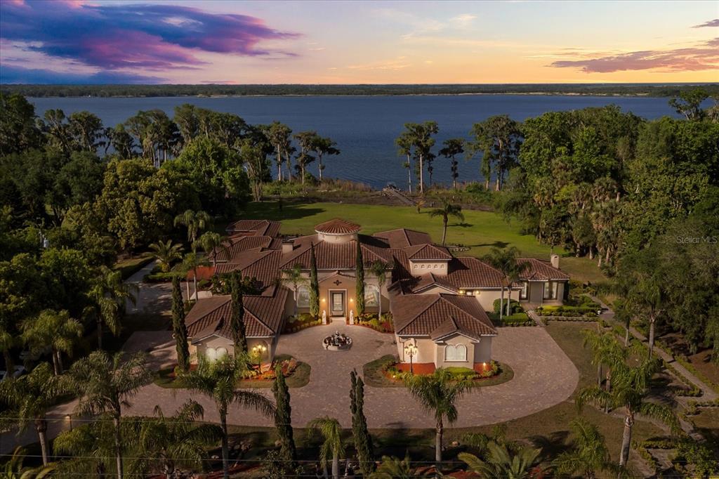 An aerial view of a large Mediterranean-style house with a tile roof and circular driveway — 1112 ORANGE AVENUE, WINTER SPRINGS, FL