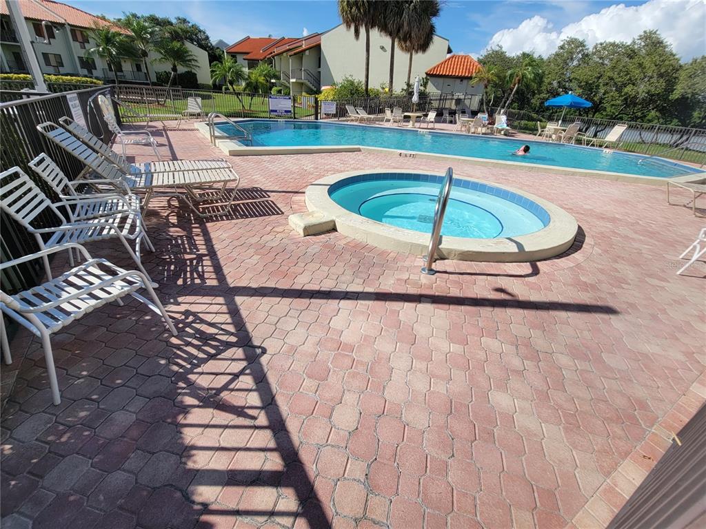 A stainless steel grill sits on a wooden deck overlooking the water and a bridge — 1515 PINELLAS BAYWAY S UNIT 38, TIERRA VERDE, FL