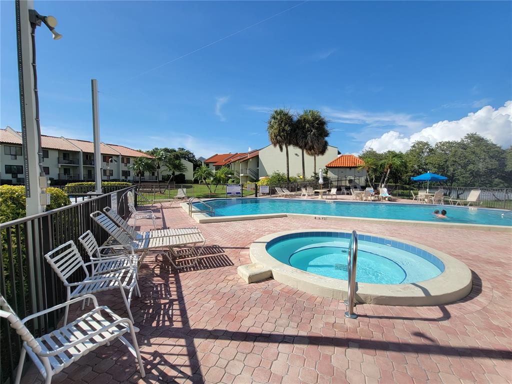 A covered balcony features two chairs, a metal railing, and a view of the water — 1515 PINELLAS BAYWAY S UNIT 38, TIERRA VERDE, FL