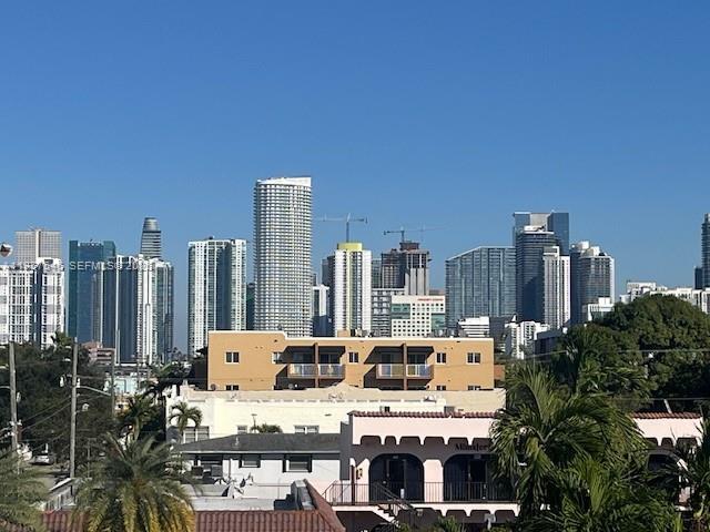 A view of the Miami skyline rises above low-rise residential buildings and palm trees — 1220 SW 5th St # 21, Miami FL 33135, MIAMI, FL