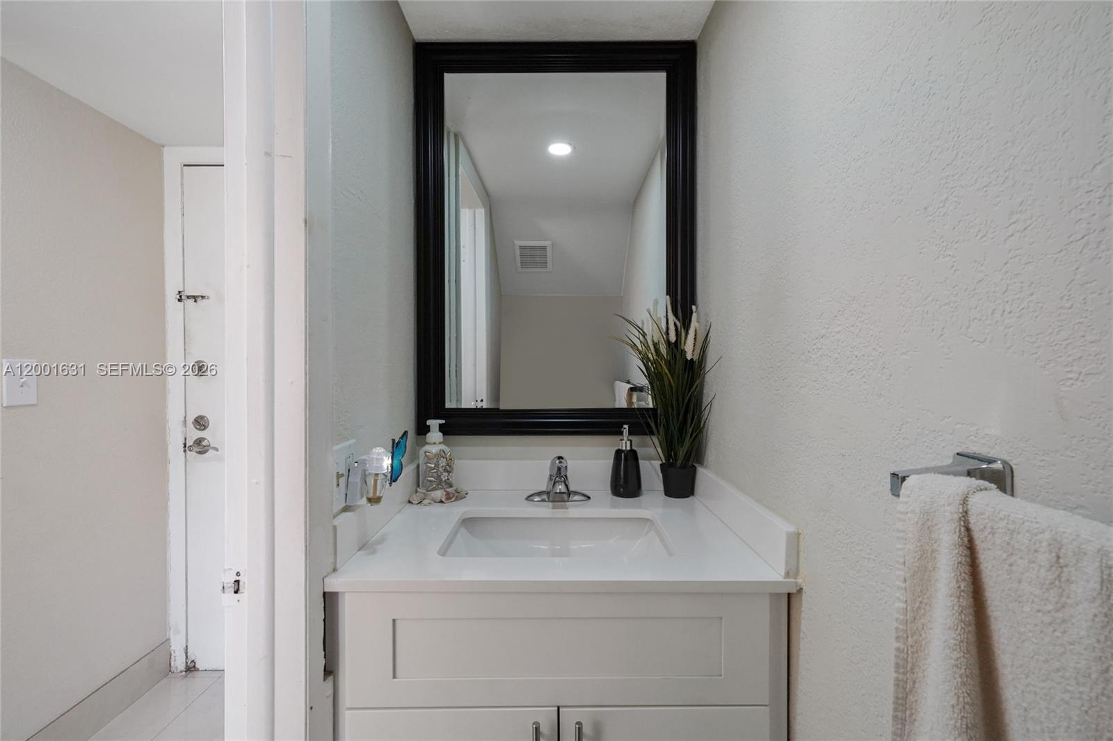 A bathroom features a white vanity, a rectangular sink, and a black-framed mirror — 1305 W 53rd St # 429, Hialeah FL 33012, HIALEAH, FL