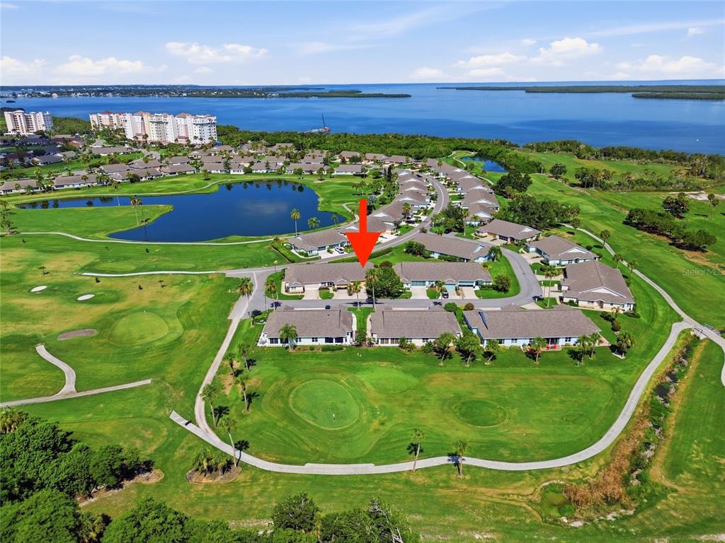 An aerial view shows a residential complex situated on a golf course near the water — 3007 LIVE OAK LANE UNIT 34, PALMETTO, FL