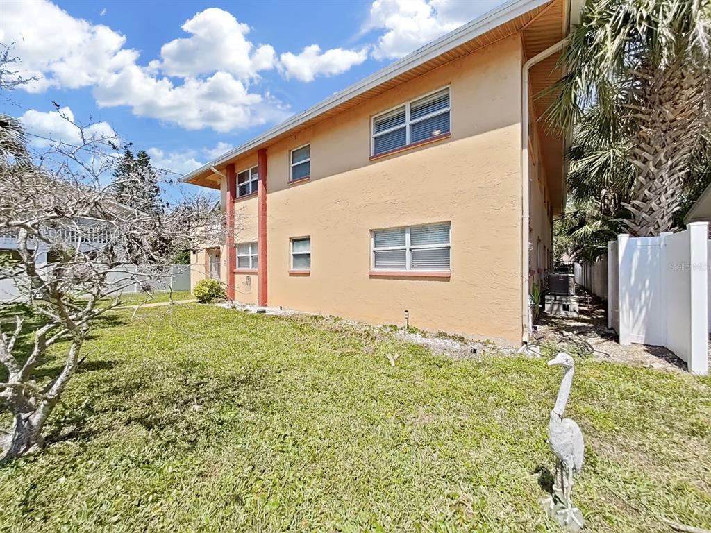 The exterior of a two-story peach-colored apartment building with a grassy yard — 206 22ND AVENUE, INDIAN ROCKS BEACH, FL