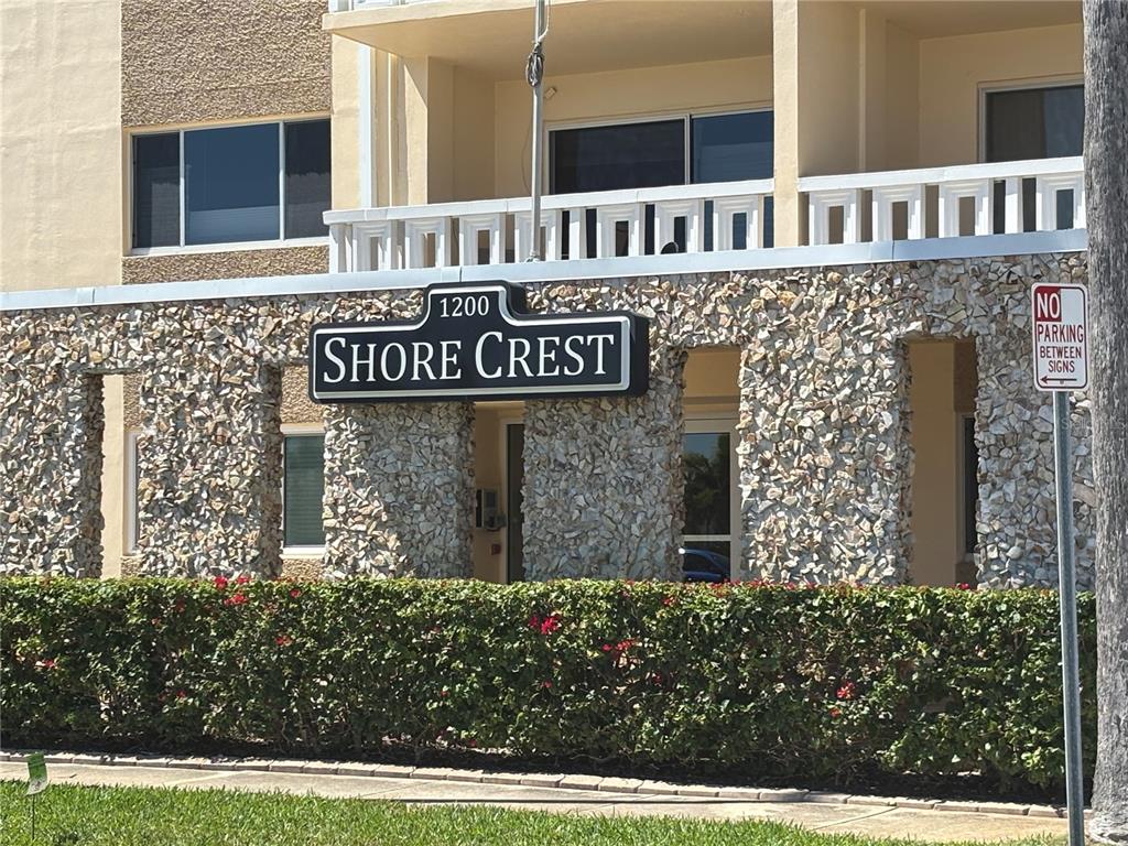 The exterior of a building features a stone facade, a Shore Crest sign, and landscaping — 1200 N SHORE DRIVE NE UNIT 212, ST PETERSBURG, FL