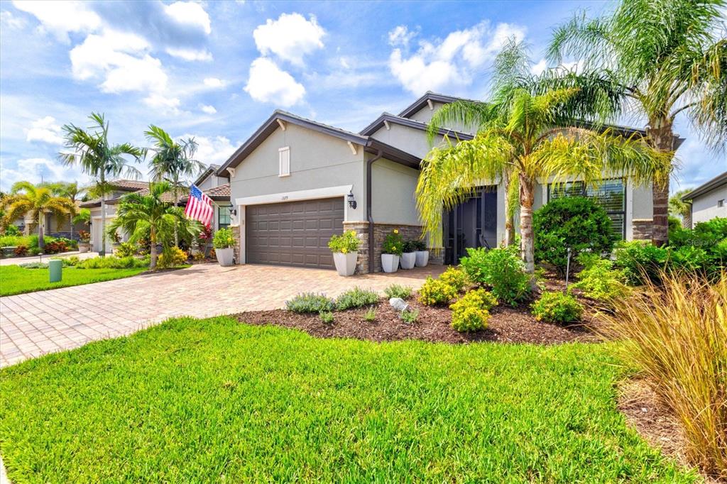 A single-story house with a paved driveway, a two-car garage, and palm trees — 13179 BORREGO STREET, VENICE, FL