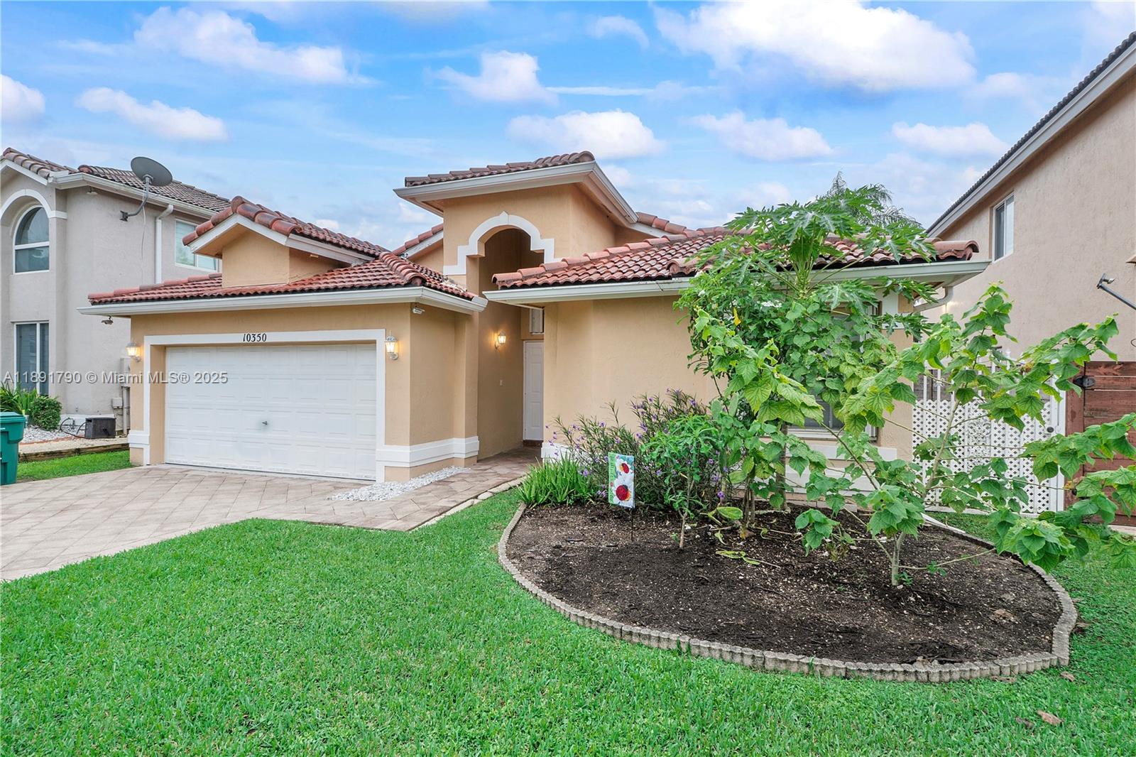 A single-story house with a tan stucco exterior, tile roof, and a front-facing garage — 10350 SW 166th Ct, Miami FL 33196, MIAMI, FL