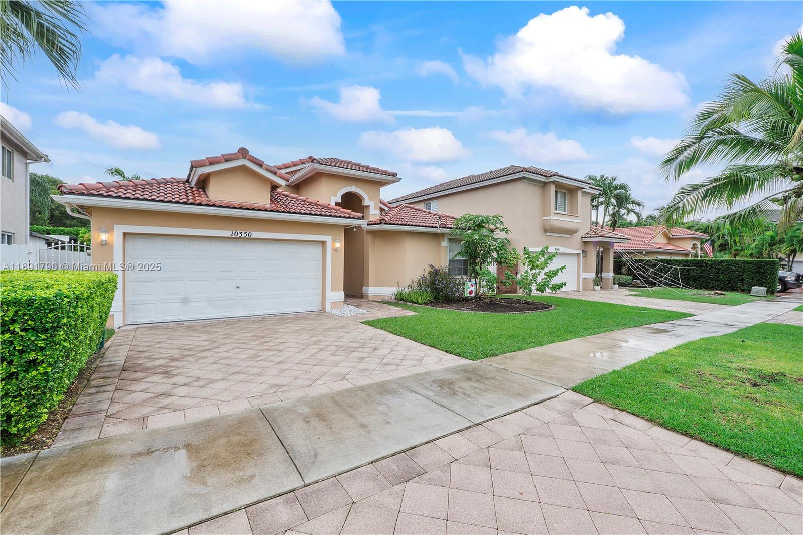 A two-story suburban house features a tan stucco exterior, a tiled roof, and a driveway — 10350 SW 166th Ct, Miami FL 33196, MIAMI, FL