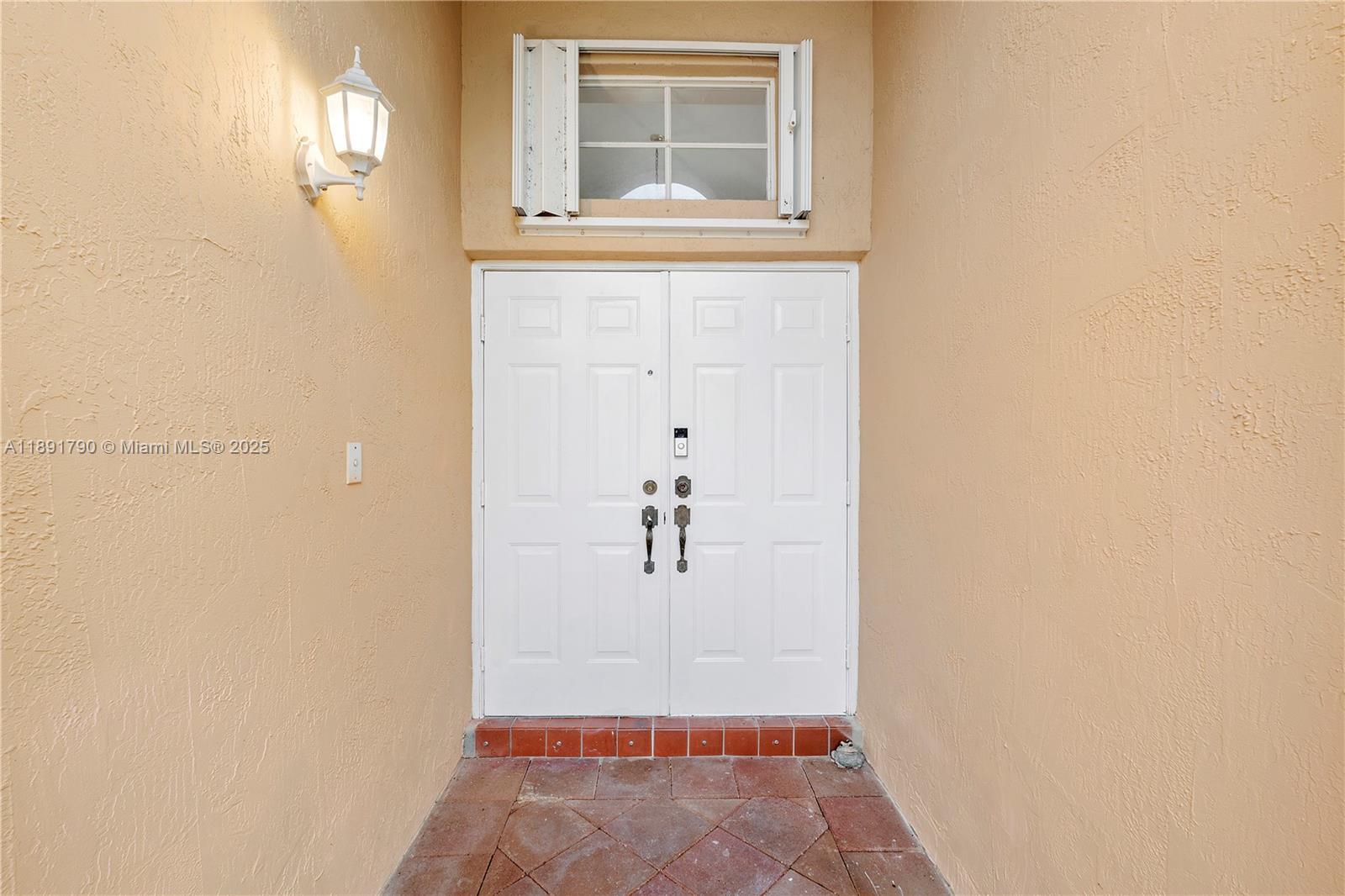 A white double front door with a transom window is set in a stucco entryway — 10350 SW 166th Ct, Miami FL 33196, MIAMI, FL