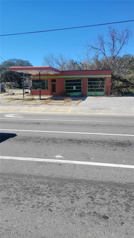 A vacant, orange-painted commercial building with a gas station canopy and two garage bays — 10 NW 250TH STREET, NEWBERRY, FL