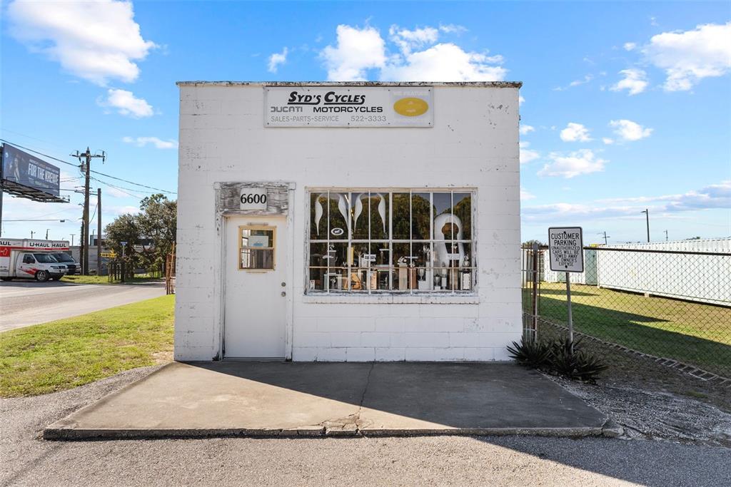 A white, single-story commercial building with a large front window and a single entrance door — 6600 HAINES ROAD N, ST PETERSBURG, FL