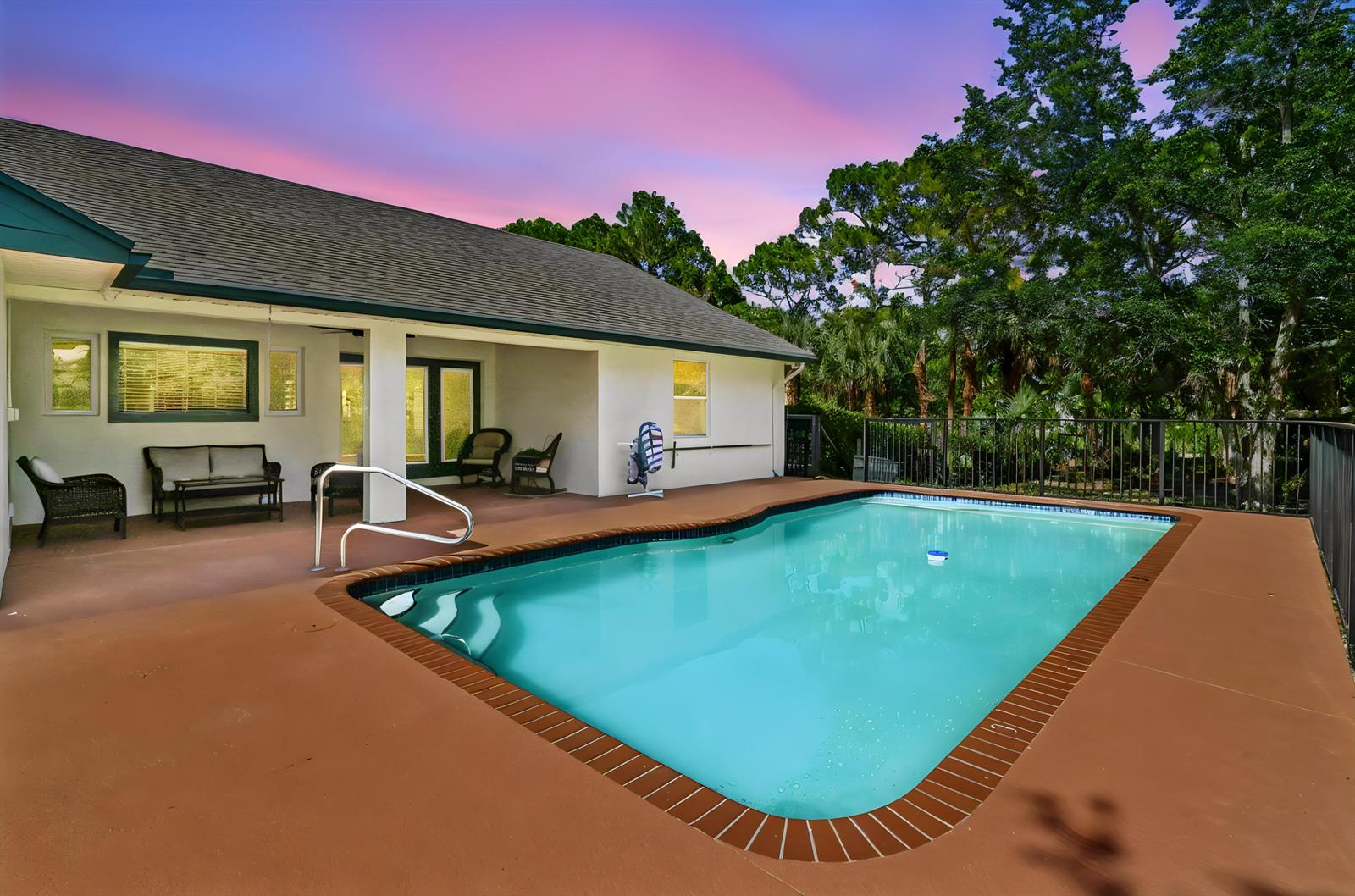 A backyard swimming pool with a brick border sits next to a covered patio area — 15286 Key Lime Boulevard, Loxahatchee FL 33470, LOXAHATCHEE, FL