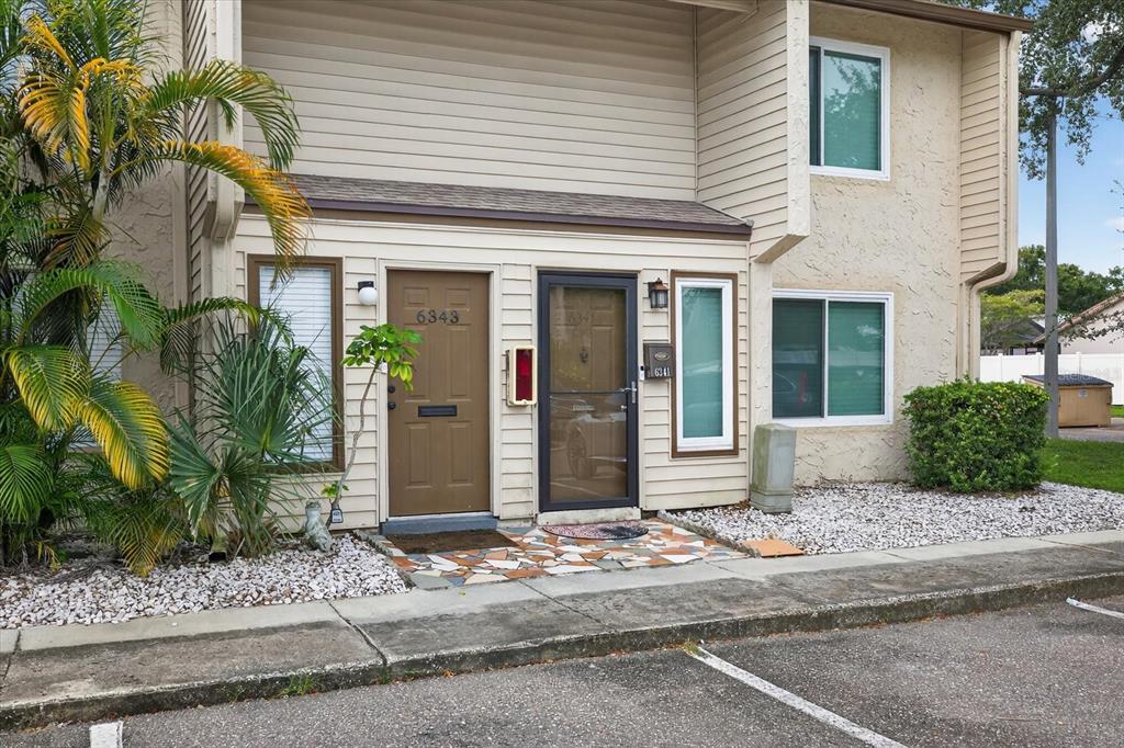 The exterior of a two-story townhouse features two adjacent front doors and a small patio — 6343 23RD STREET N, ST PETERSBURG, FL