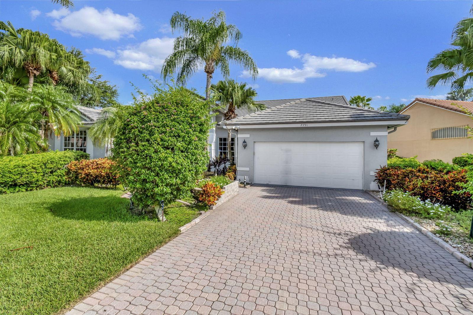 A single-story house with a gray exterior, a two-car garage, and a paved driveway — 7791 Bridlington Drive, Boynton Beach FL 33472, BOYNTON BEACH, FL