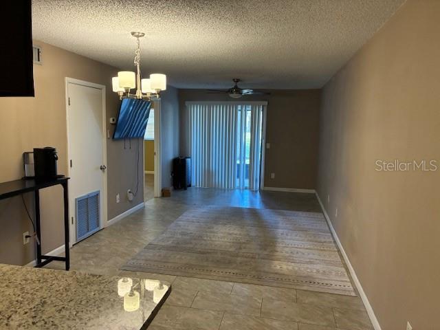This living room features a chandelier, a ceiling fan, and a sliding glass door — 3806 N OAK DRIVE UNIT V21, TAMPA, FL