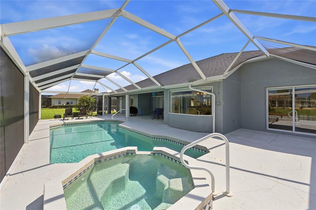 A screened-in patio features a swimming pool, a raised spa, and a concrete deck — 816 BOUNDARY BOULEVARD, ROTONDA WEST, FL