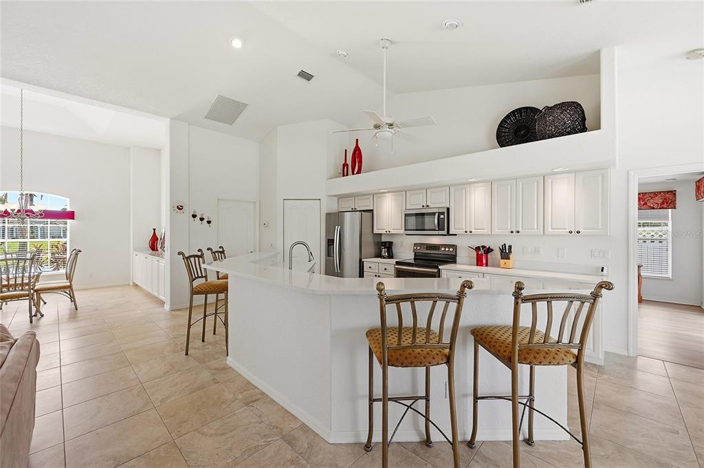 A kitchen features white cabinets, stainless steel appliances, a breakfast bar, and tile flooring — 816 BOUNDARY BOULEVARD, ROTONDA WEST, FL
