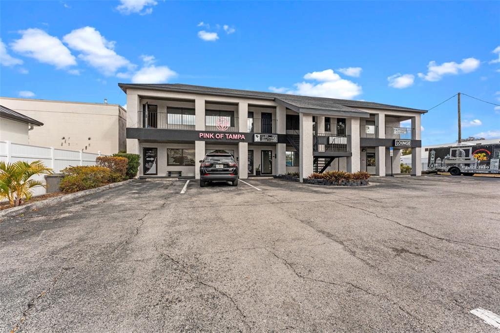 A two-story commercial building with a parking lot and a black SUV parked in front — 3007 W CYPRESS STREET, TAMPA, FL