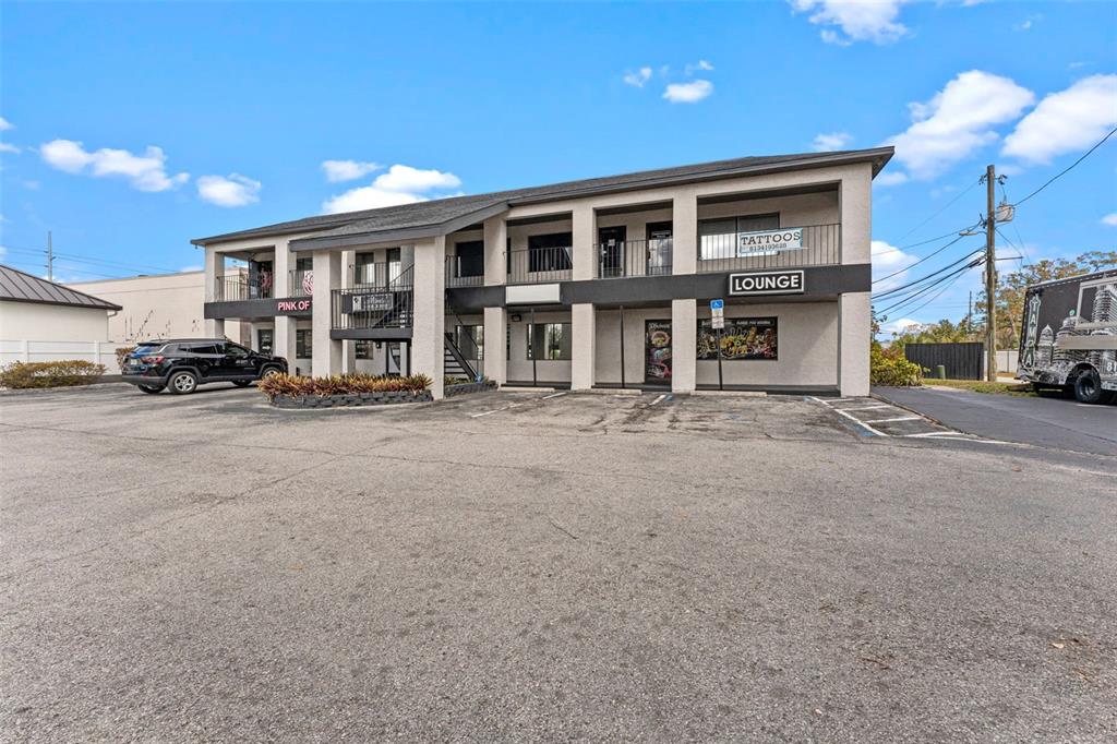 A two-story commercial building with a parking lot and a black SUV parked outside — 3007 W CYPRESS STREET, TAMPA, FL