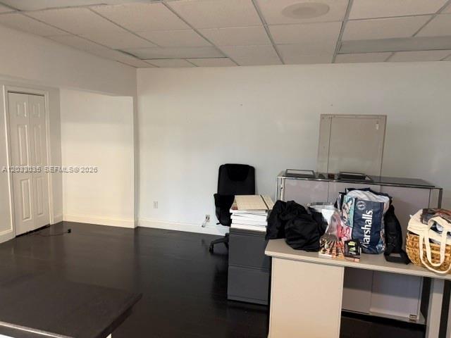 An office space features dark wood flooring, a white desk, and a black office chair — 4627 Ponce De Leon Blvd, Coral Gables FL 33146, CORAL GABLES, FL