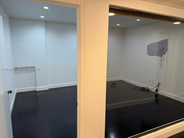 An interior view shows two adjacent rooms with dark hardwood floors and white walls — 4627 Ponce De Leon Blvd, Coral Gables FL 33146, CORAL GABLES, FL
