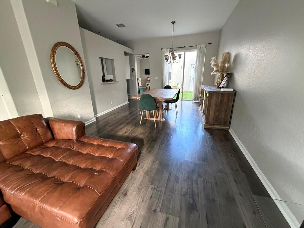 A living and dining area features a brown leather sofa, wood flooring, and a dining table — 2403 NW 7th Street, Boynton Beach FL 33426, BOYNTON BEACH, FL