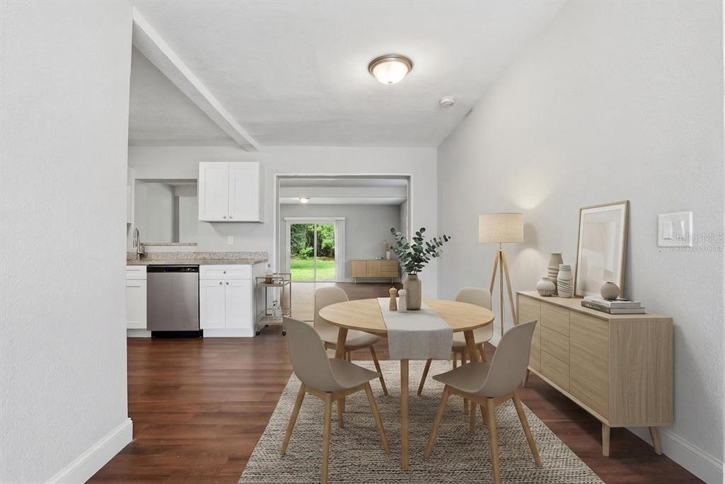 A dining area with a round table and chairs sits adjacent to a white kitchen — 917 KENSINGTON DRIVE, ORLANDO, FL