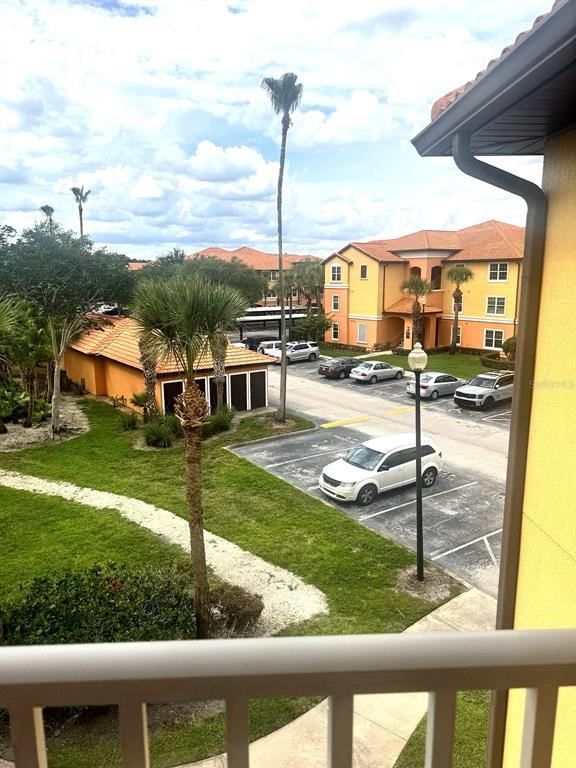 An elevated view shows a parking lot between two yellow apartment buildings with palm trees — 5483 VINELAND ROAD UNIT 10309, ORLANDO, FL