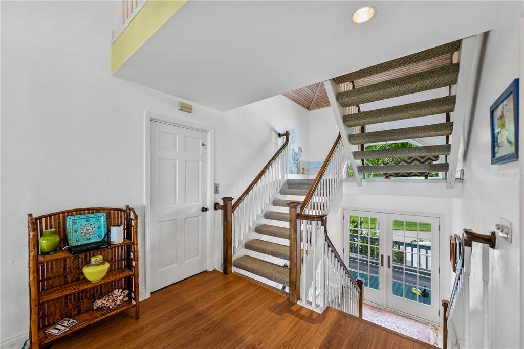 An entryway features wood flooring, a white door, and a staircase with carpeted steps — 12 SEAWATCH DRIVE, BOCA GRANDE, FL