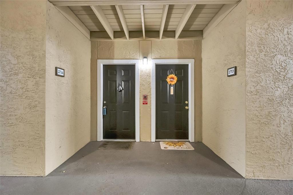 An exterior view shows two dark brown apartment doors with unit numbers 2714 and 2713 — 4065 CROCKERS LAKE BOULEVARD UNIT 14, SARASOTA, FL