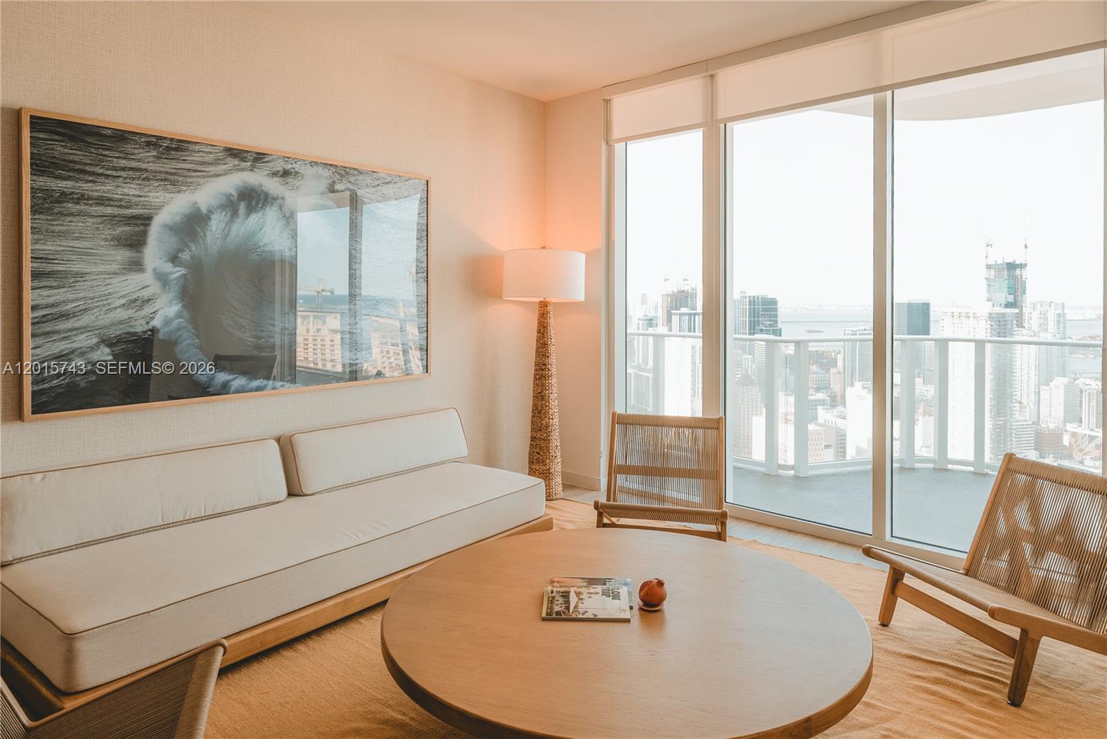 A living room features a light-colored sofa, a round wooden table, and floor-to-ceiling windows — 275 SW 6th St # 5307, Miami FL 33130, MIAMI, FL