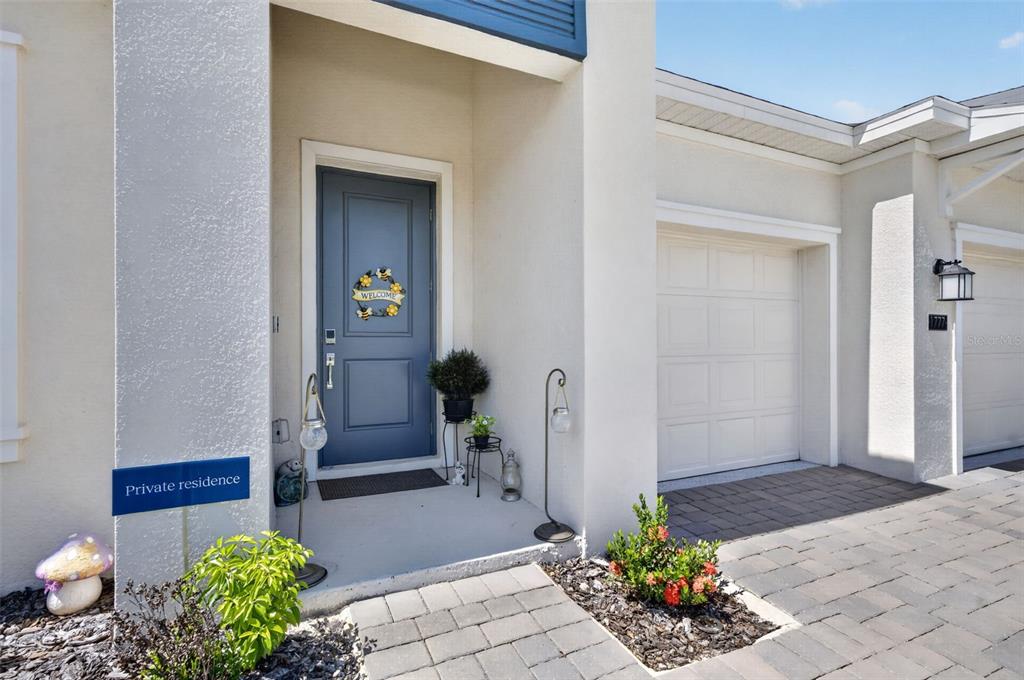 The exterior of a home features a blue front door, a garage, and a walkway — 1777 RIDER RAIN LANE, APOPKA, FL