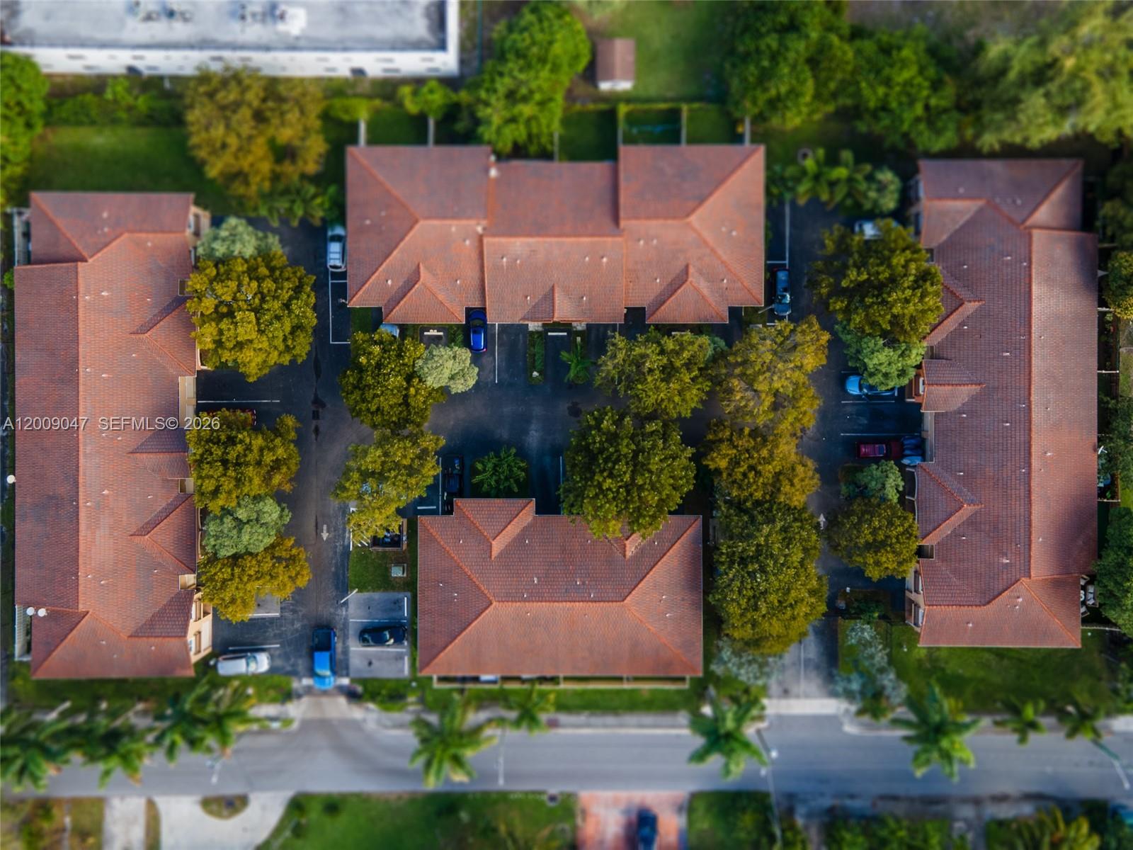 An aerial view shows several residential buildings with red-tiled roofs and surrounding parking areas — 59 SE 3rd Ave # 59, Hallandale Beach FL 33009, HALLANDALE BEACH, FL