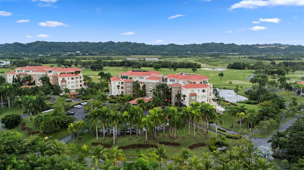 An aerial view shows two large, multi-story buildings with red tile roofs amidst tropical landscaping — Carr. 693 Km.10 HM 7 PLANTATION VILLAGE DRIVE UNIT 1202, DORADO, PR