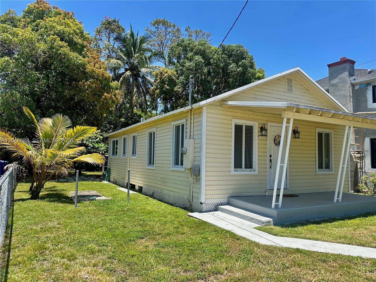 A light yellow, single-story house with a front porch stands on a grassy lawn — 3611 OAK AV, Miami FL 33133, MIAMI, FL