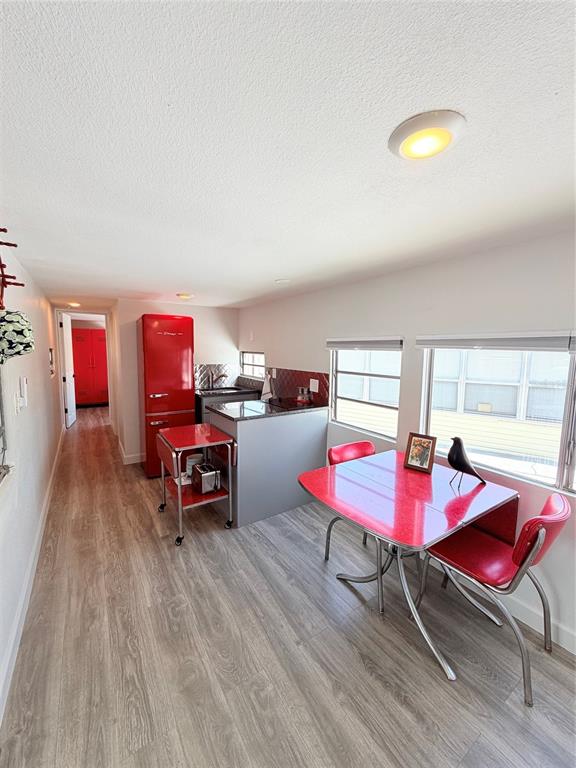 A kitchen and dining area with red retro-style furniture and light wood-look flooring — 110 KOVE BOULEVARD, OSTEEN, FL