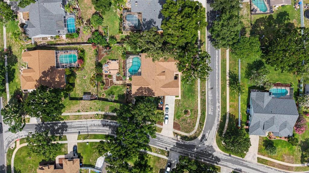 An aerial view shows several suburban houses with swimming pools and surrounding trees and streets — 3916 BROOMSEDGE LANE, VALRICO, FL