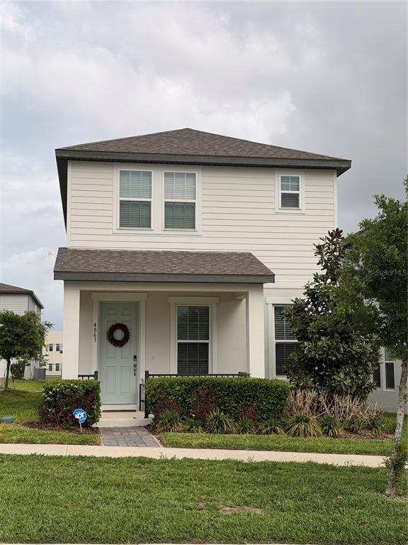 A two-story house with light siding, a covered front porch, and a light blue door — 4863 LACEWING DRIVE, WINTER GARDEN, FL