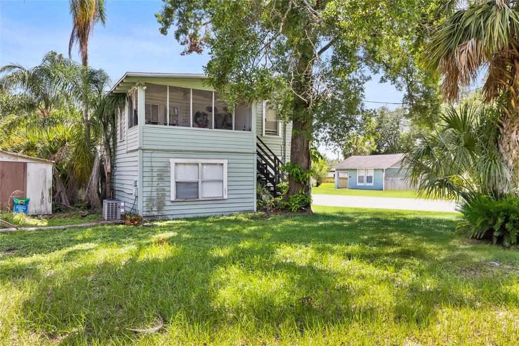 A two-story light green house with a screened-in porch and an exterior staircase — 128 W NORTH STREET, TAMPA, FL